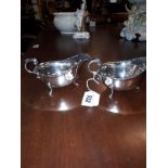 Pair of English silver sauce boats, having a plain baluster body, a cast flying scroll handle,