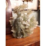 Oriental jade carving mounted on wooden stand.