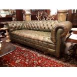 20th. C. hand dyed leather upholstered chesterfield couch raised on turned mahogany legs.