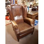 Pair of brown leather wingback armchairs.