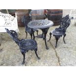 Decorative cast iron garden table with 3 matching chairs.