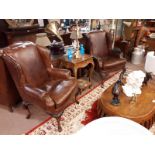 Pair of leather upholstered armchairs on cabriole legs.