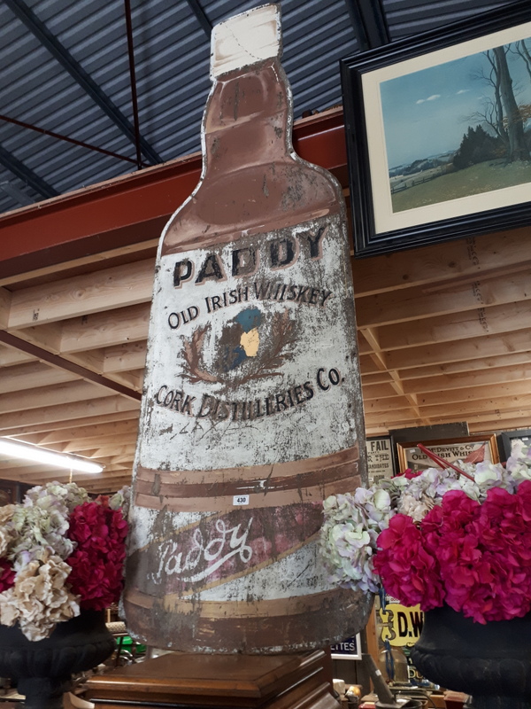 Large wooden PADDY's WHISKEY advertisment in the form of a bottle.