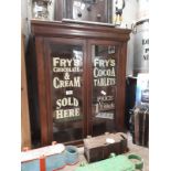 Two door mahogany display cabinet advertising Fry's Chocolate Sold Here.