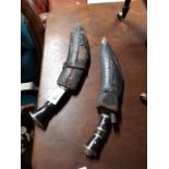 Two Gurkha kukri knives with scabbards.