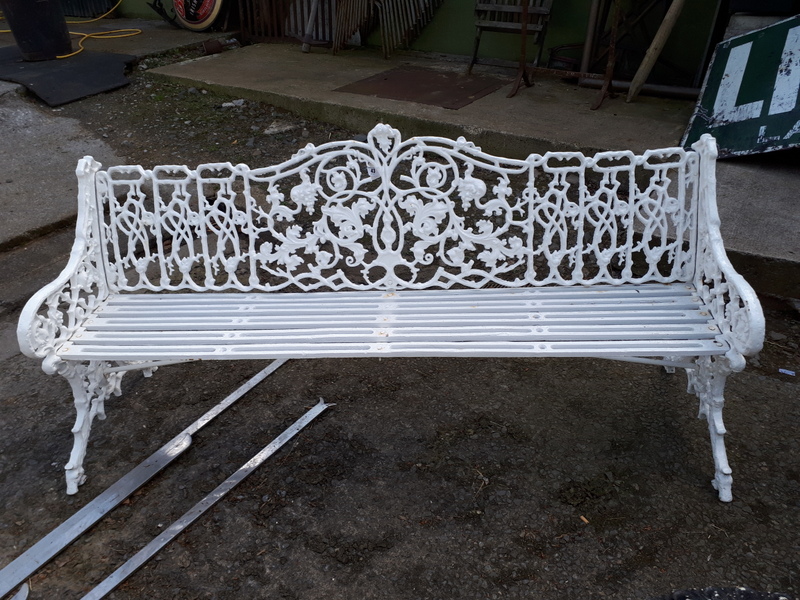 Wrought iron four seat decorative garden bench.