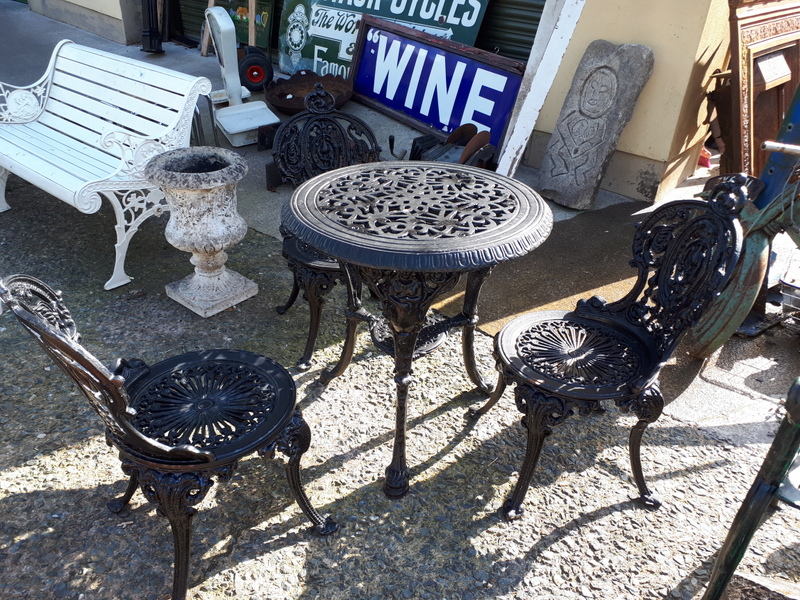 Decorative cast iron garden table with 3 matching chairs.