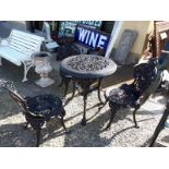 Decorative cast iron garden table with 3 matching chairs.