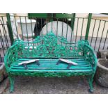 Cast iron three seater metal garden seat with wooden slats decorated with oak leaves.