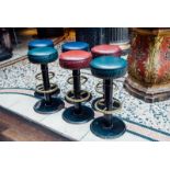 Set of six cast iron stools with brass foot rails.