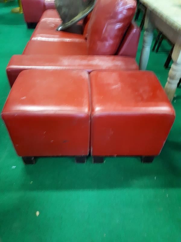 Six red leather pouffes.