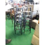 Fifteen metal stool frames.