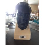 Carved stone head on sandstone base signed with hologram