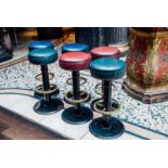 Set of six cast iron stools with brass foot rails.