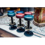Set of six cast iron stools with brass foot rails.