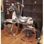 Wooden painted tricycle in the form of a horse.