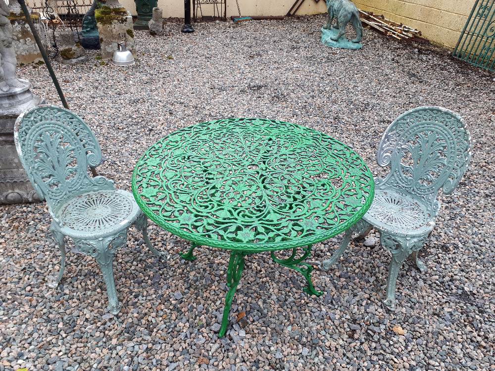 Decorative 20th C.cast garden table and two chairs.