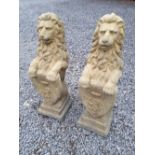 Pair of composition stone lions holding shields.