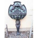 Decorative wall fountain the back and bowl decorated with lions raised on the body of a lion with