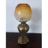 19th C. brass oil lamp in the esthetic style with original amber shade. 19 Inches High.