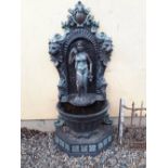 Decorative bronze wall fountain the back decorated ith lion's masks and a maiden standing on a