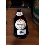 Advertising clock in the form of a Guinness bottle.