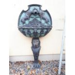 Decorative wall fountain the back and bowl decorated with lions raised on the body of a lion with