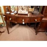 Georgian mahogany bowfronted cabinet with three drawers in frieze and four turned legs.