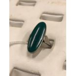 Silver dress ring with inset green stone.