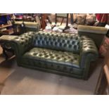 Two seater green leather chesterfield.