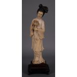 Scultura in avorio raff. ''GUANYIN CON FIORE''. Base in legno finemente lavorata. Cina. Inizi XX