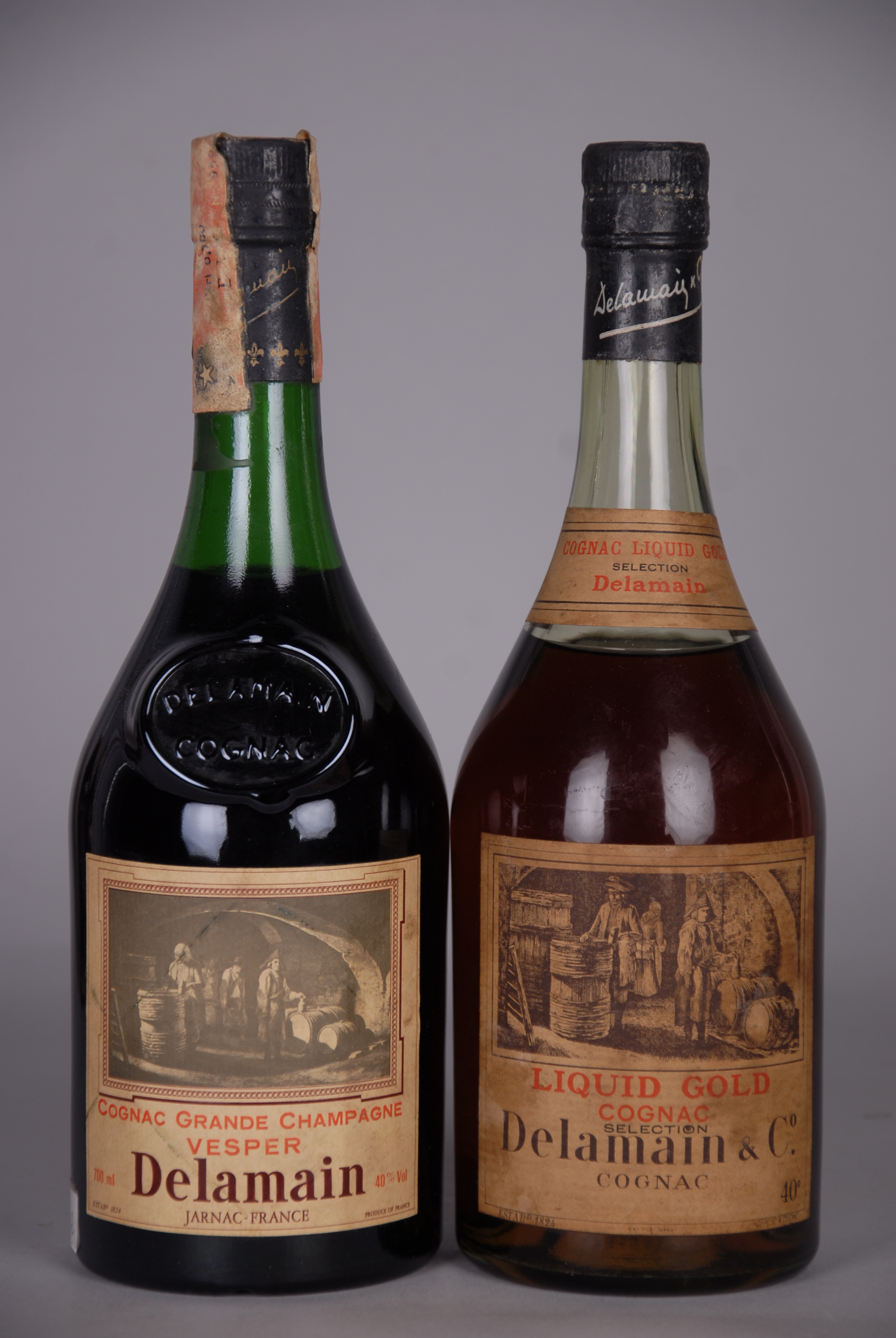 Coppia di Cognac DELAMAIN: - Cognac 'Liquid Gold Selection'. Esemplare anni '60. Indicazione in