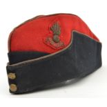 An officer’s scarlet and blue sidecap of The R Artillery, gilt piping and embroidered badge.