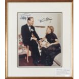 A full length coloured photograph signed “Ginger Rogers” and “Fred Astaire”, he seated on the arm of