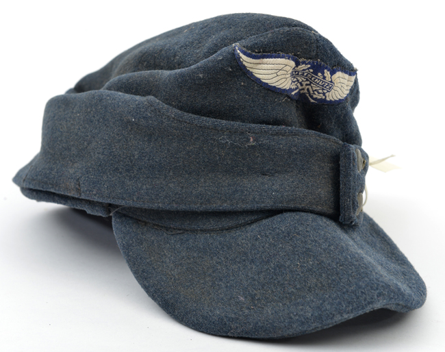 A Third Reich M43 Luftschutz grey/blue ski cap, with woven badge, the lining with maker’s stamp “