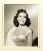 A waist length studio photographic portrait of Linda Darnell, mounted and framed, with inset