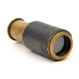 A miniature brass telescope, chequered leather covered body, length extended 1¾”, of a type used
