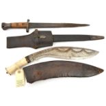 A kukri, blade 12½” etched overall with festooned panels, bone hilt, in its brown leather scabbard