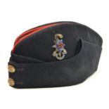 An officer’s blue sidecap of The R Sussex Regt, scarlet piping to top, enamelled silver plated