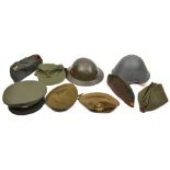 An Eastern Bloc steel helmet; a Dutch WWII steel helmet (no lining); a US Vietnam period forage cap;