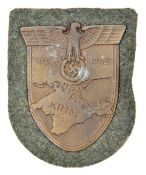 A Third Reich Krim shield, on field grey patch with paper backing. GC unissued (small patch of