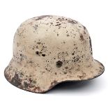 A Third Reich M42 Russian Front combat helmet, with matt white paint over the original grey/green