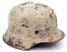 A Third Reich M42 Russian Front combat helmet, with matt white paint over the original grey/green