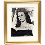 A head and shoulders studio photographic portrait signed “Susan Hayward”, mounted and framed in gilt