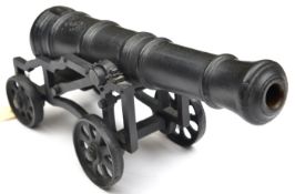 A modern cast iron model cannon, the 15” barrel of good form, on its open work 4 wheeled iron
