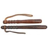 A plain dark wood truncheon, shaped grip, 15½” (wood distressed) and another, lighter wood, shaped