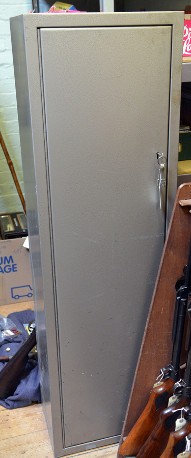A grey painted steel gun cabinet for 4 guns, 18” x 12”x 60”, with top shelf for ammunition and 2