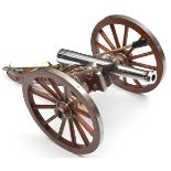 A large well detailed model cannon, with chrome plated barrel and pale wood carriage with cleaning
