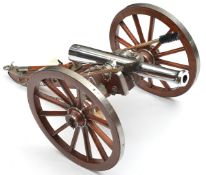 A large well detailed model cannon, with chrome plated barrel and pale wood carriage with cleaning
