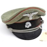 A Third Reich Waffen SS Artillery officer’s peaked cap, with metal eagle and death’s head, red